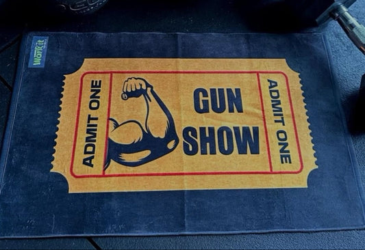 Gym mat with 'Gun Show' ticket design and gym equipment in the background