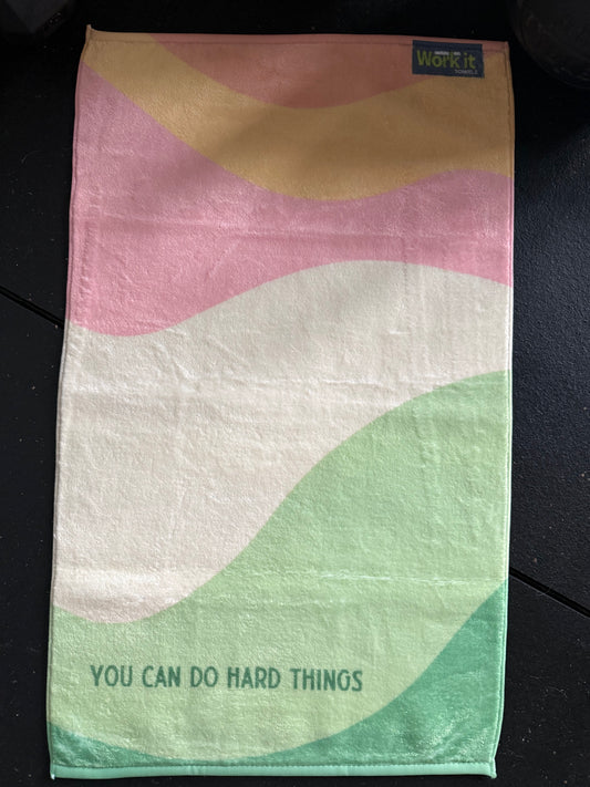 Towel with abstract design and motivational text on a dark surface