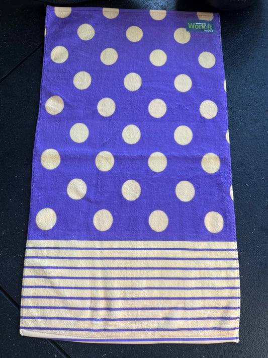 purple towel with gold polka dots and purple stripes on a black background