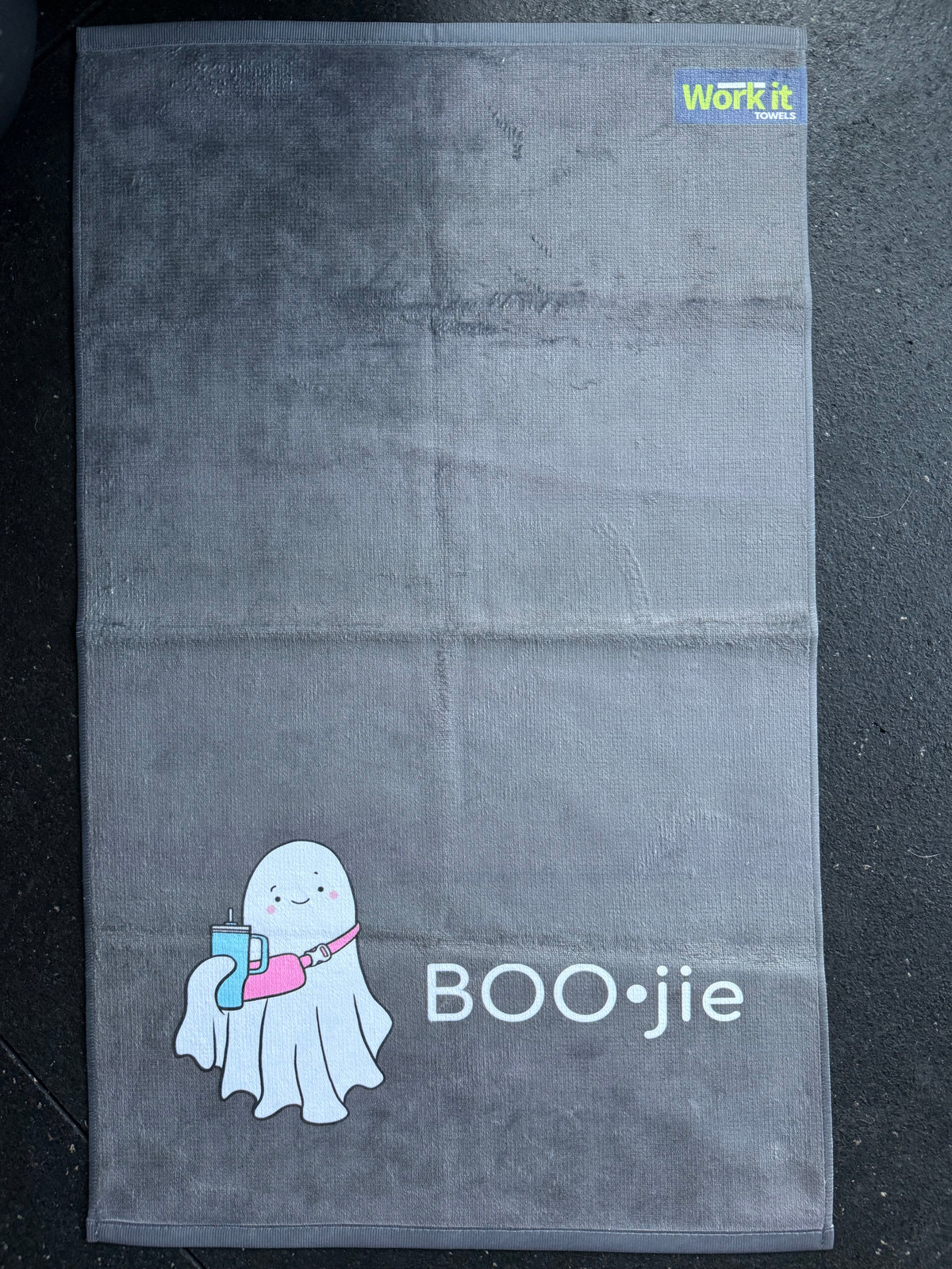 Gray towel with a cartoon ghost and 'BOO•jie' text on a dark background