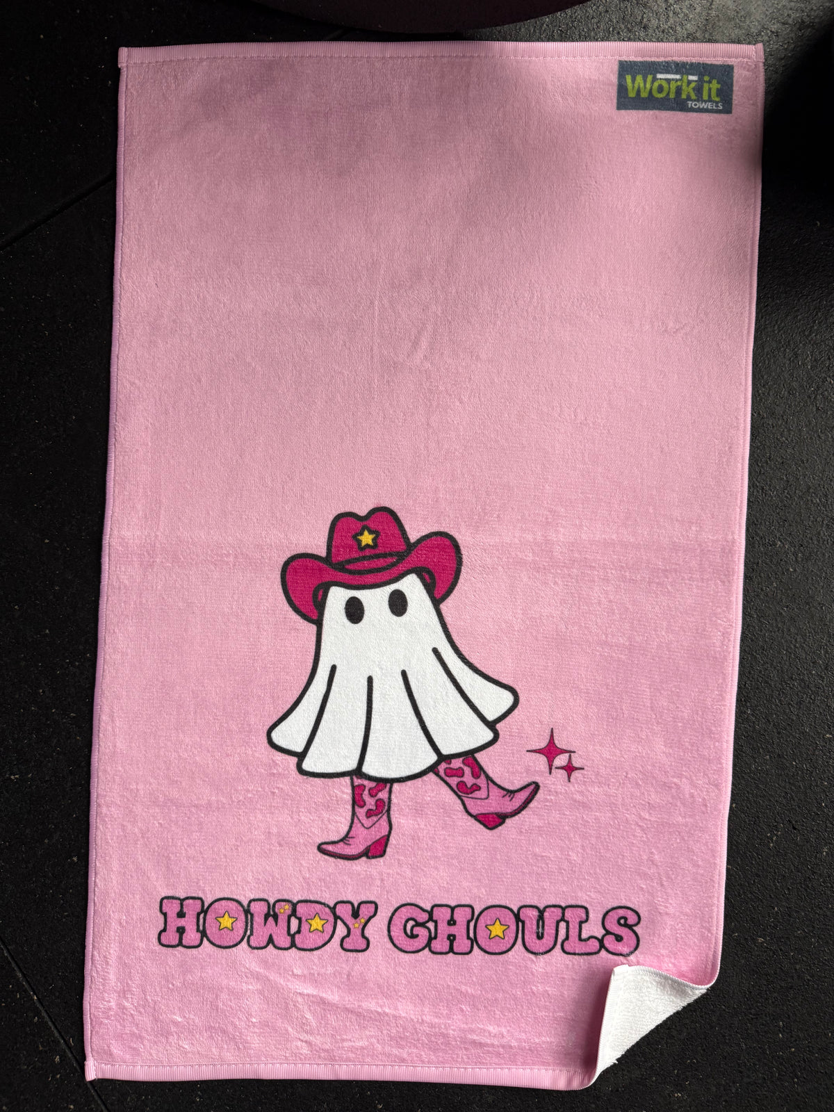 Pink towel with a cartoon ghost cowgirl character and 'Howdy Ghoul' text on a black background
