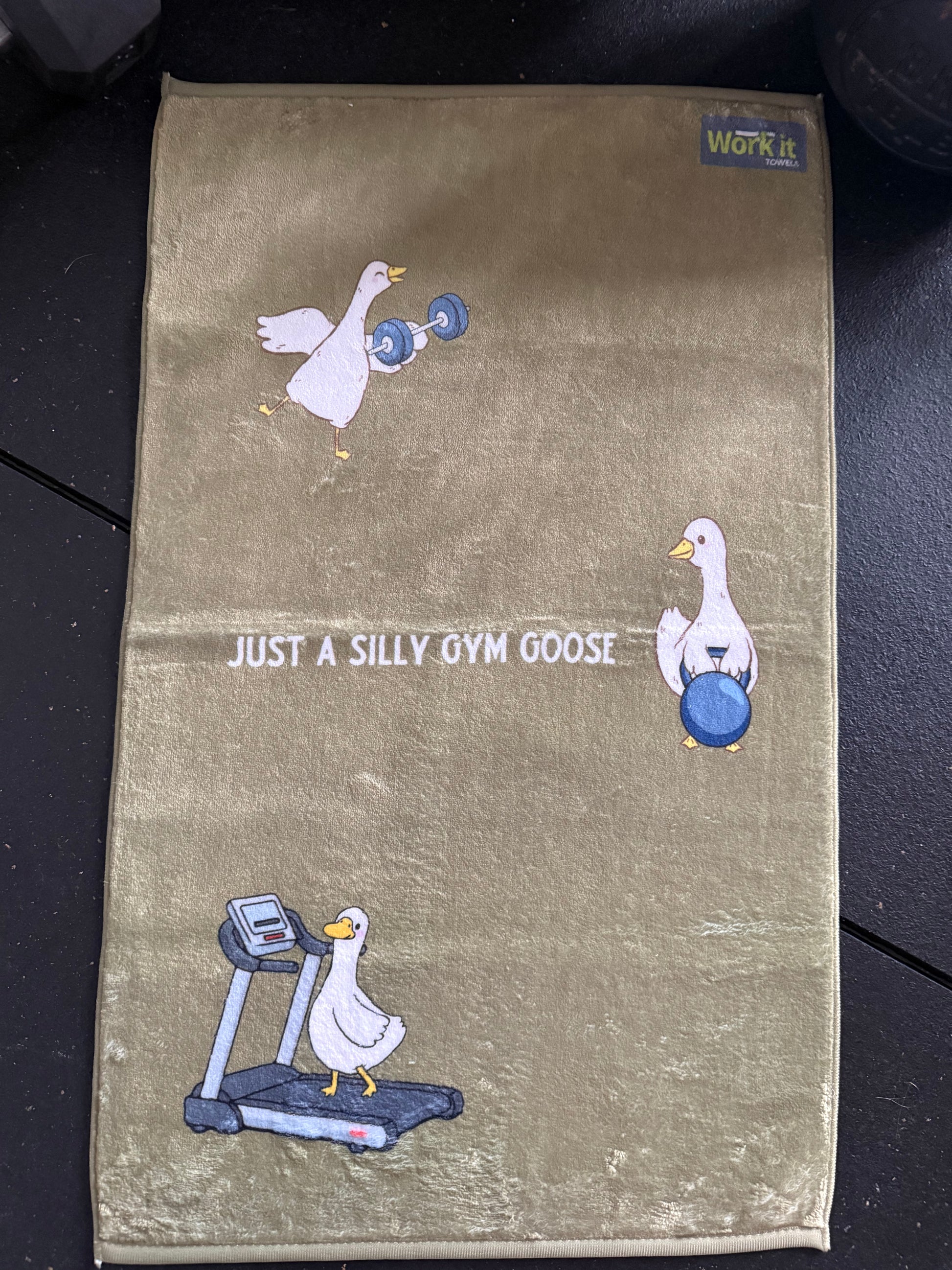 Towel with cartoon goose design and text on a dark background