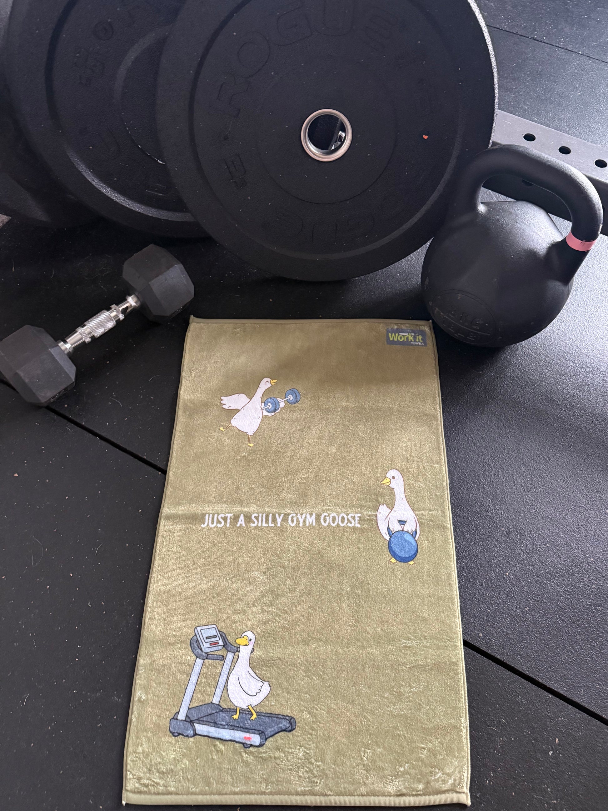 Towel with cartoon silly goose designs on a gym floor with weights