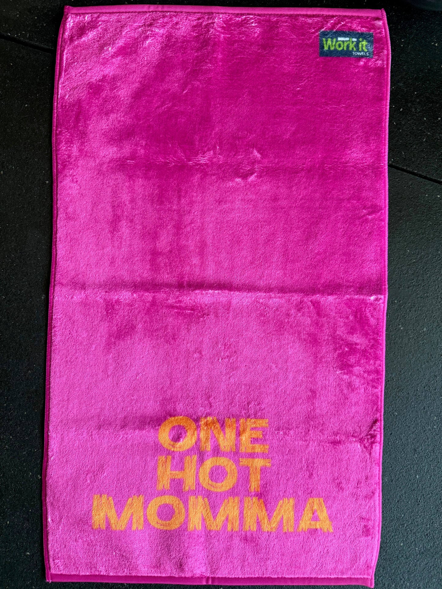 Pink towel with 'ONE HOT MOMMA' text on a black background