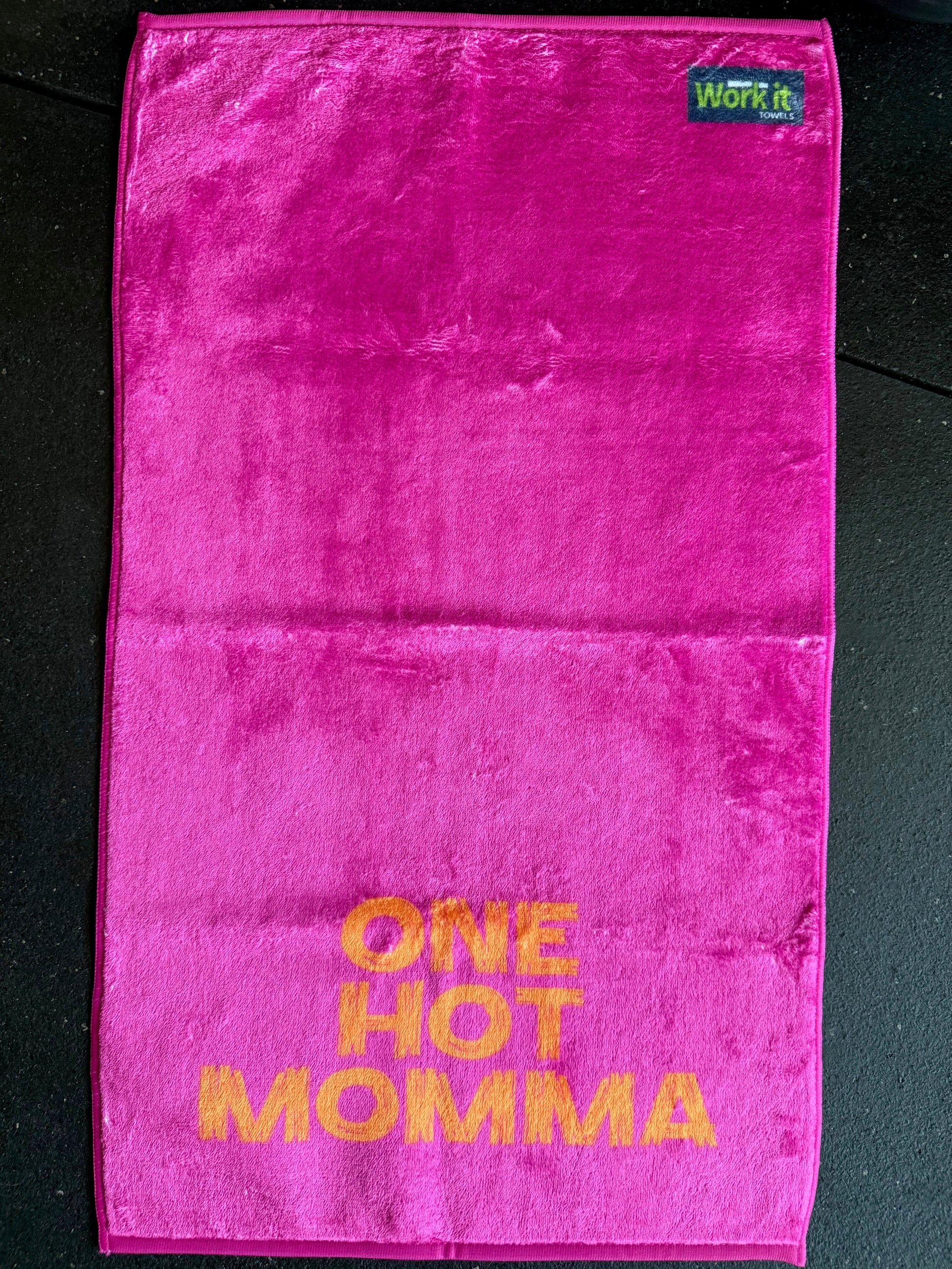 Pink towel with 'ONE HOT MOMMA' text on a black background