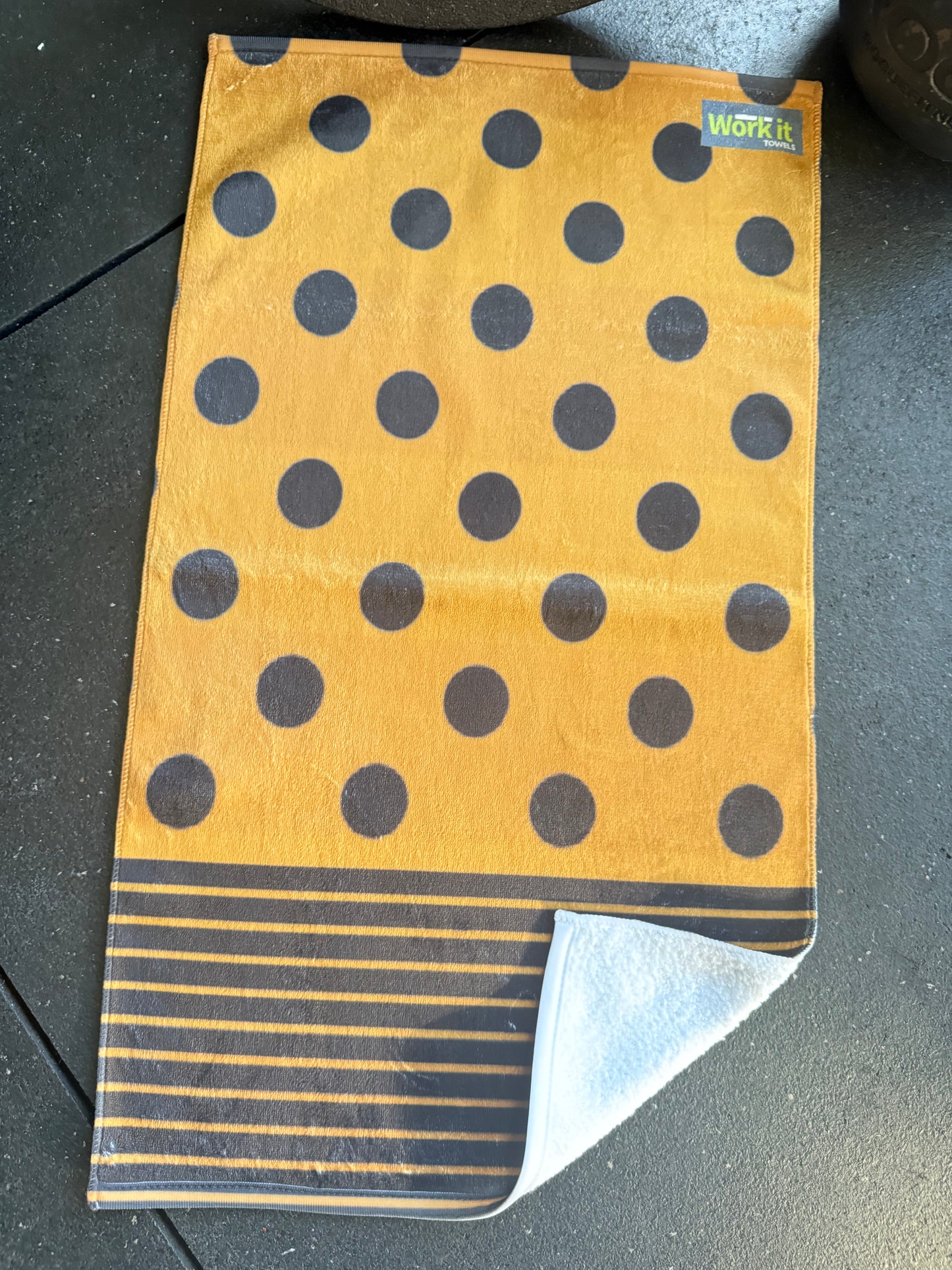 Polka dot towel with a visible brand label on a dark surface