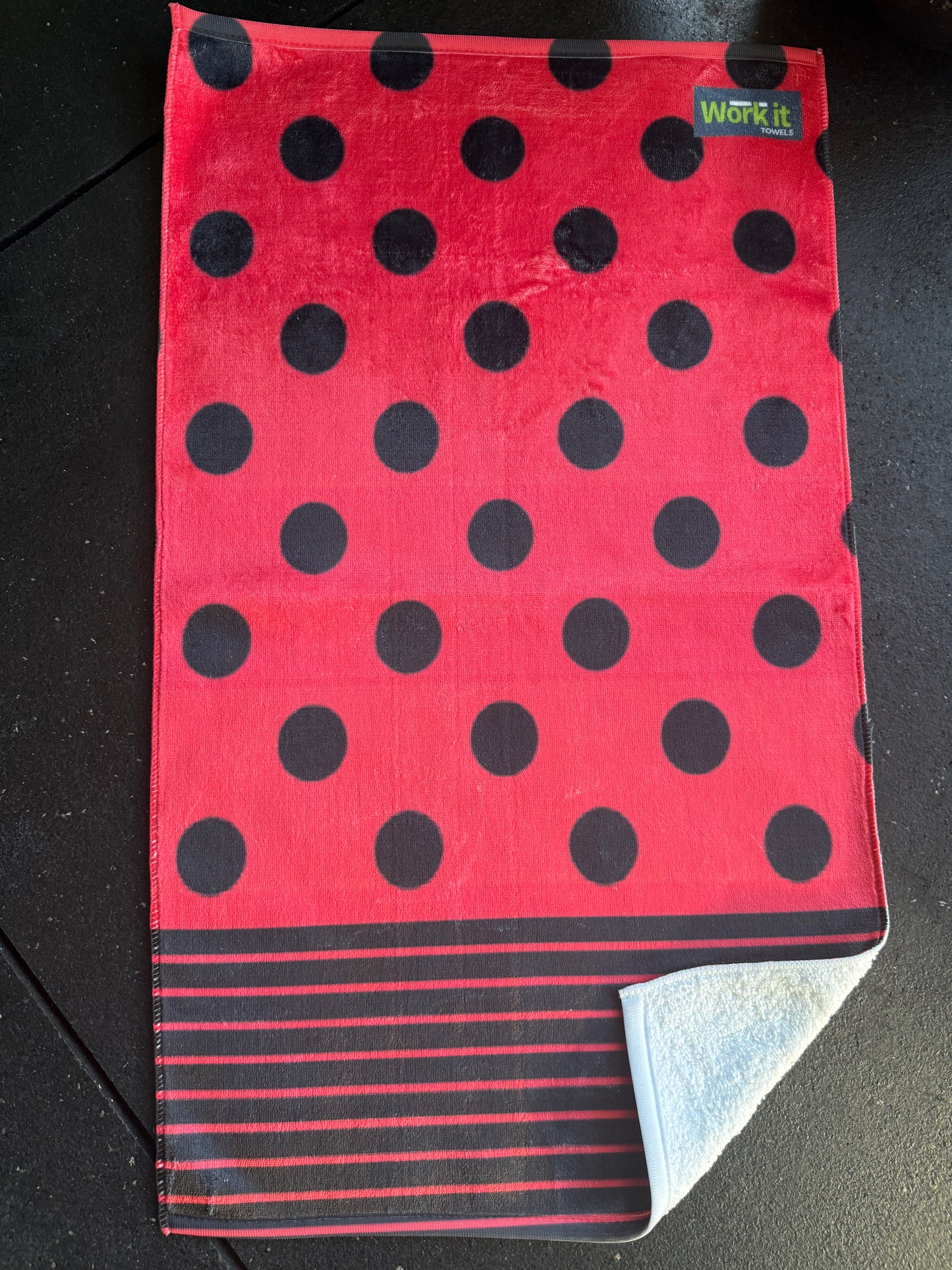 Red towel with black polka dots on a dark surface
