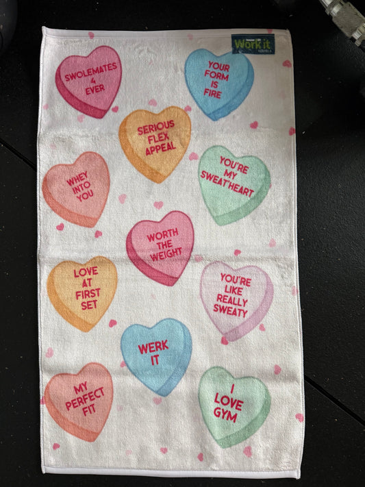 Towel with colorful heart-shaped text on a black background