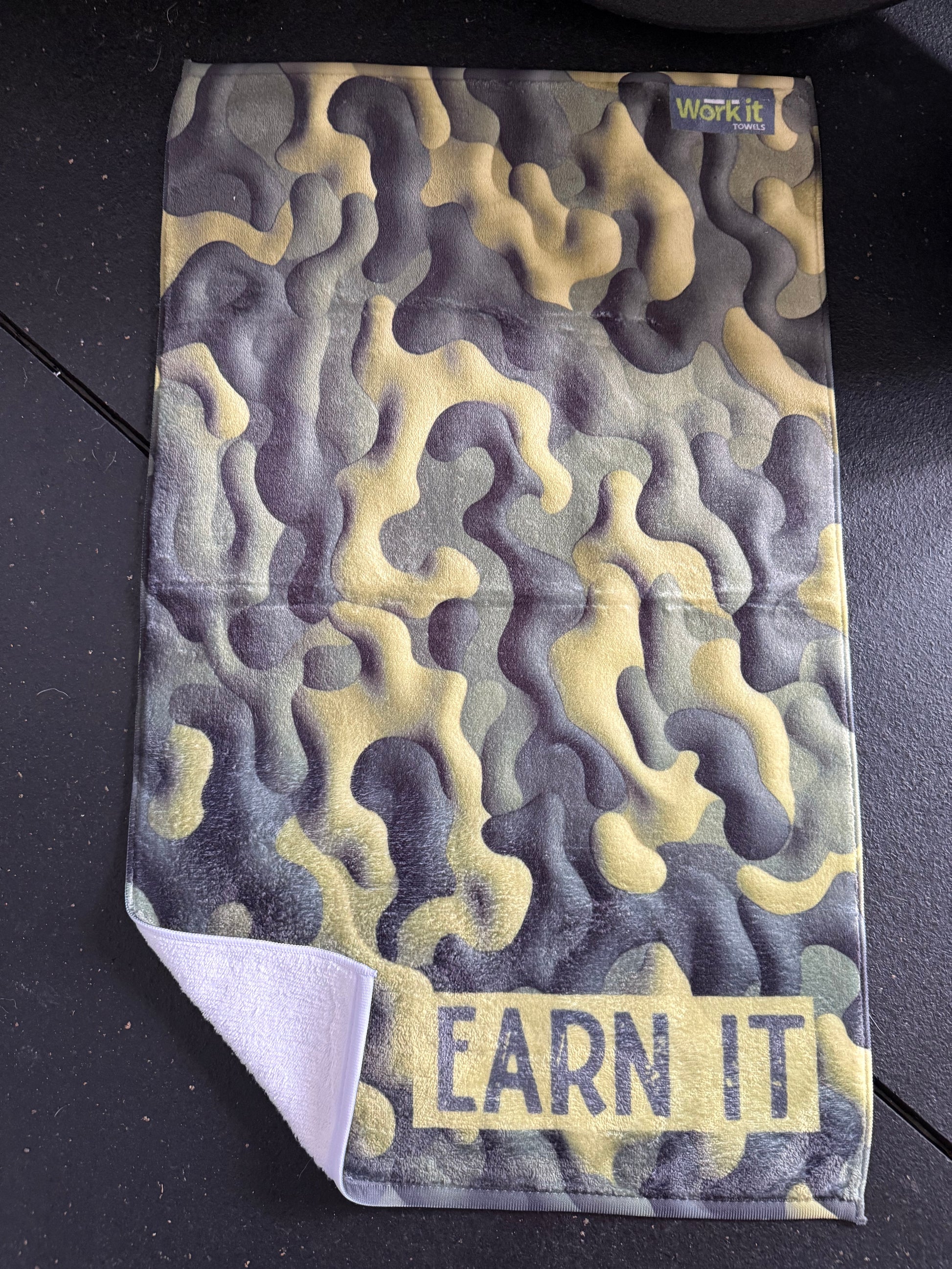 Textured fabric with wavy pattern and 'Earn It' text on a black background