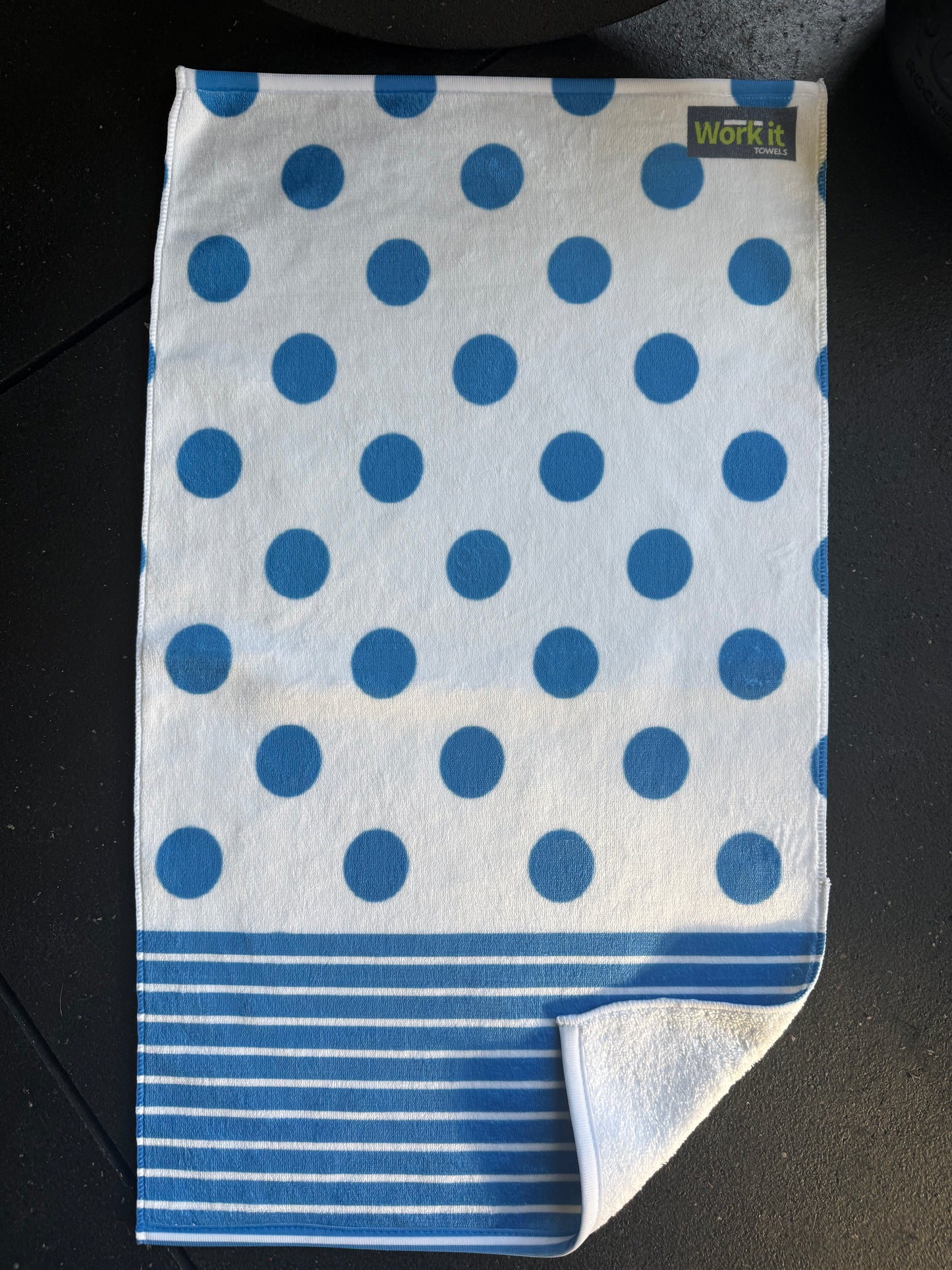 Folded towel with blue polka dot pattern on a black surface