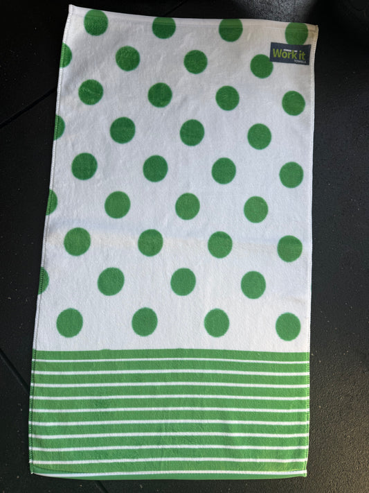 Green and white polka dot towel with a brand label on a black surface