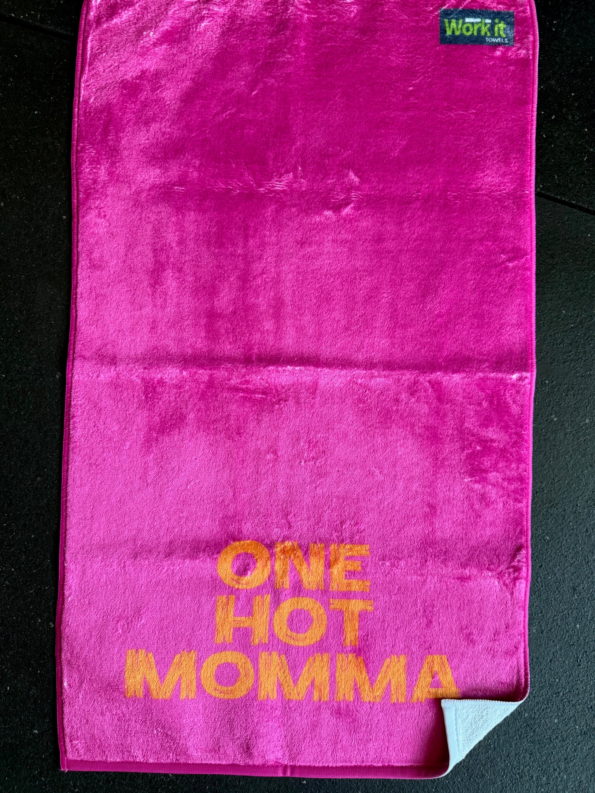 Pink towel with 'ONE HOT MOMMA' text on a black background