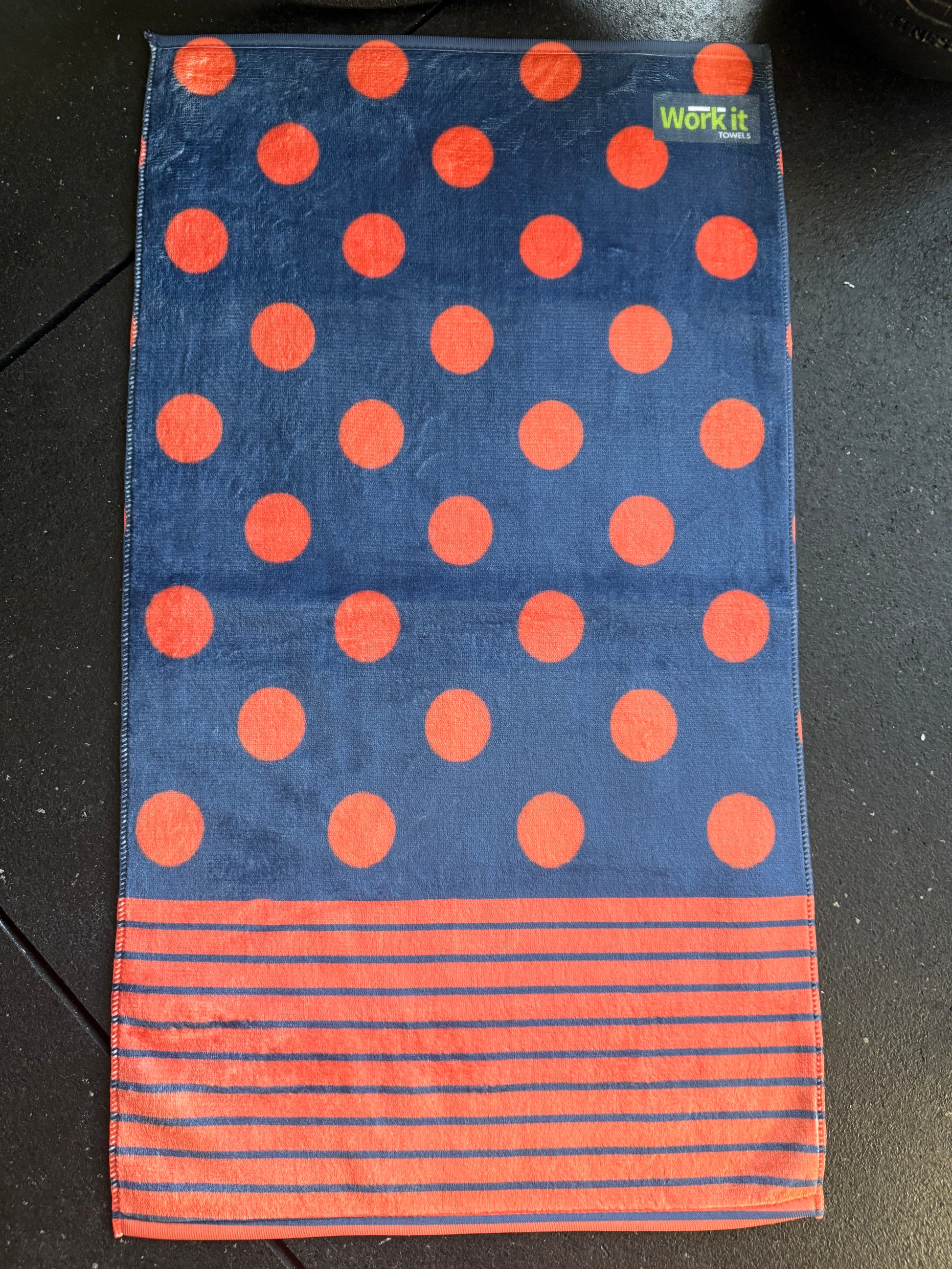 Towel with red polka dots and stripes on a dark surface