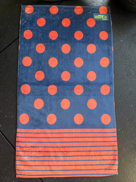 Towel with red polka dots and stripes on a dark surface