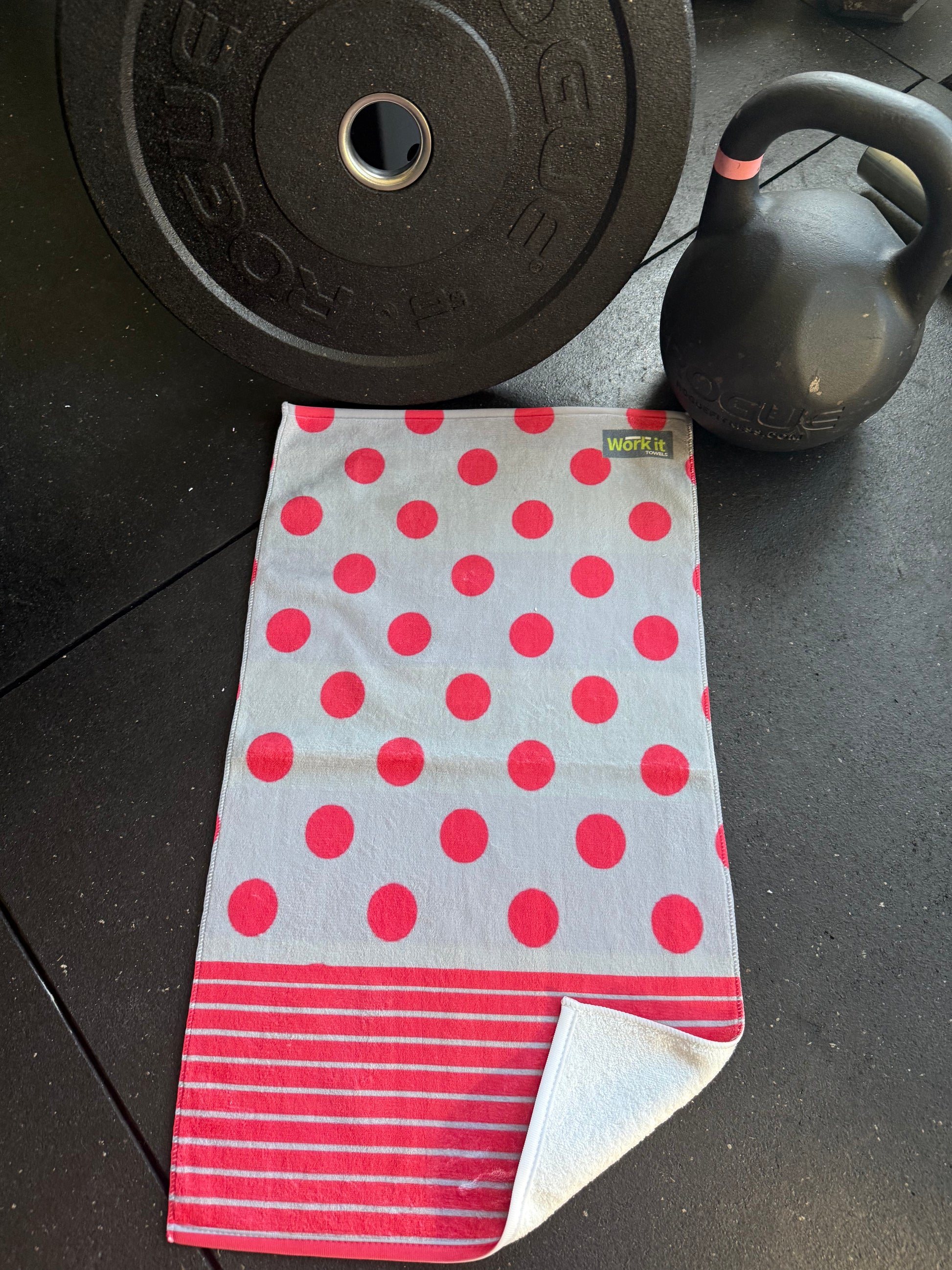 Polka dot towel on a black surface with gym equipment in the background