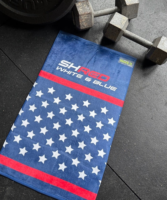 Blue towel with white star pattern and red border on a black surface with weights.