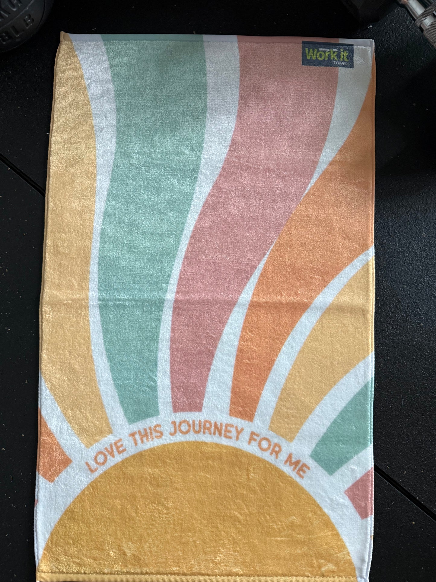 Colorful towel with abstract design and text on a black background