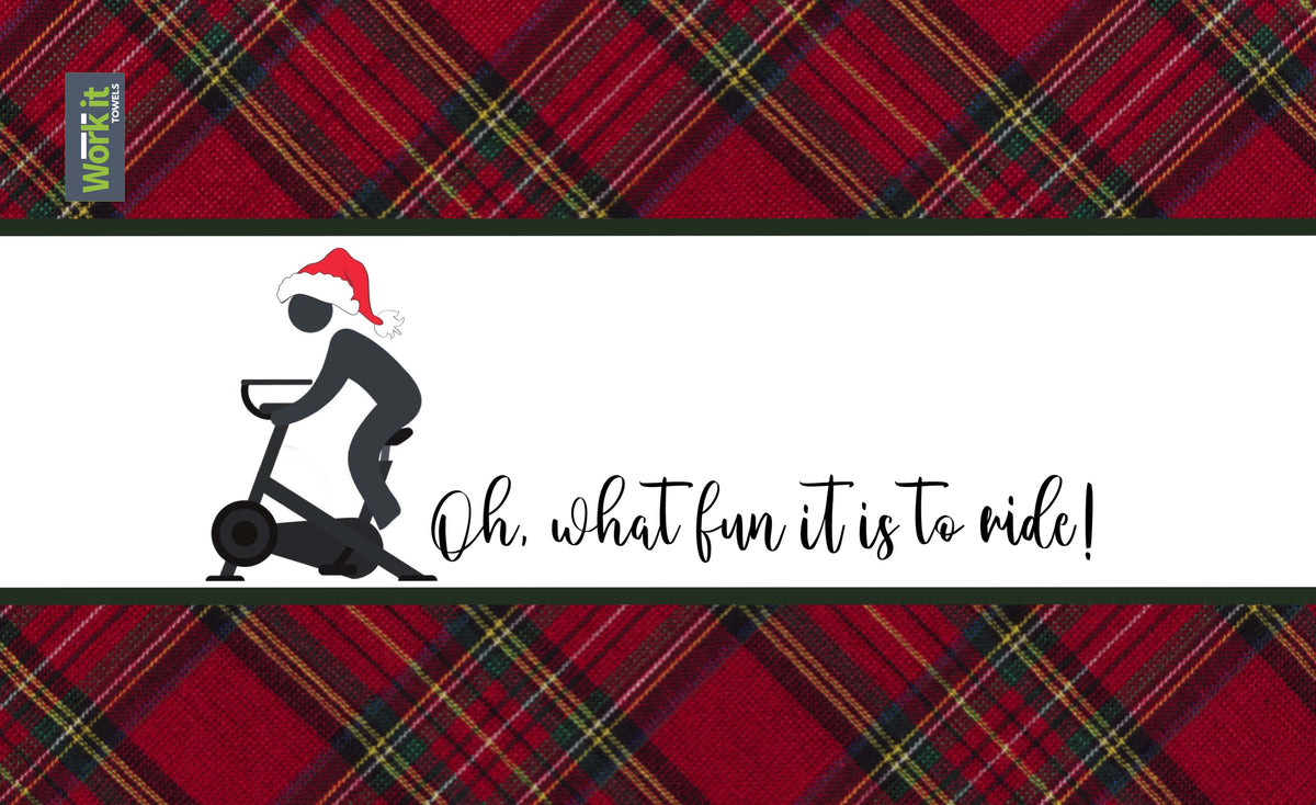 A gym towel with a plaid pattern at the bottom and a design featuring a person on a bike with the text 'Oh what fun it is to RIDE!' on the upper part of the towel.